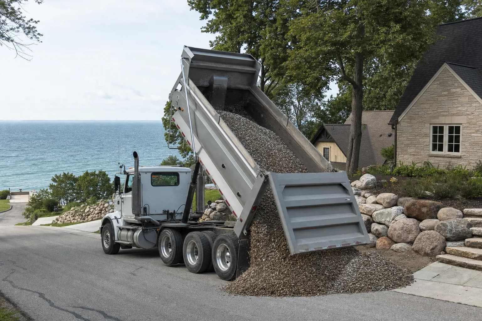Dump truck delivering gravel to a residential property